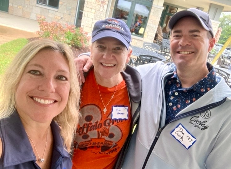 Three people smiling at outdoor event