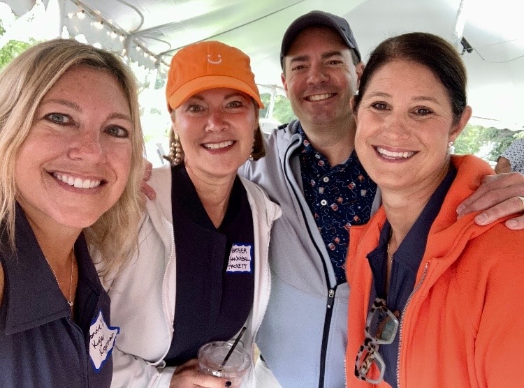 Four people smiling at outdoor event