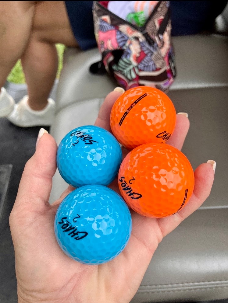 Hand holding colored golf balls
