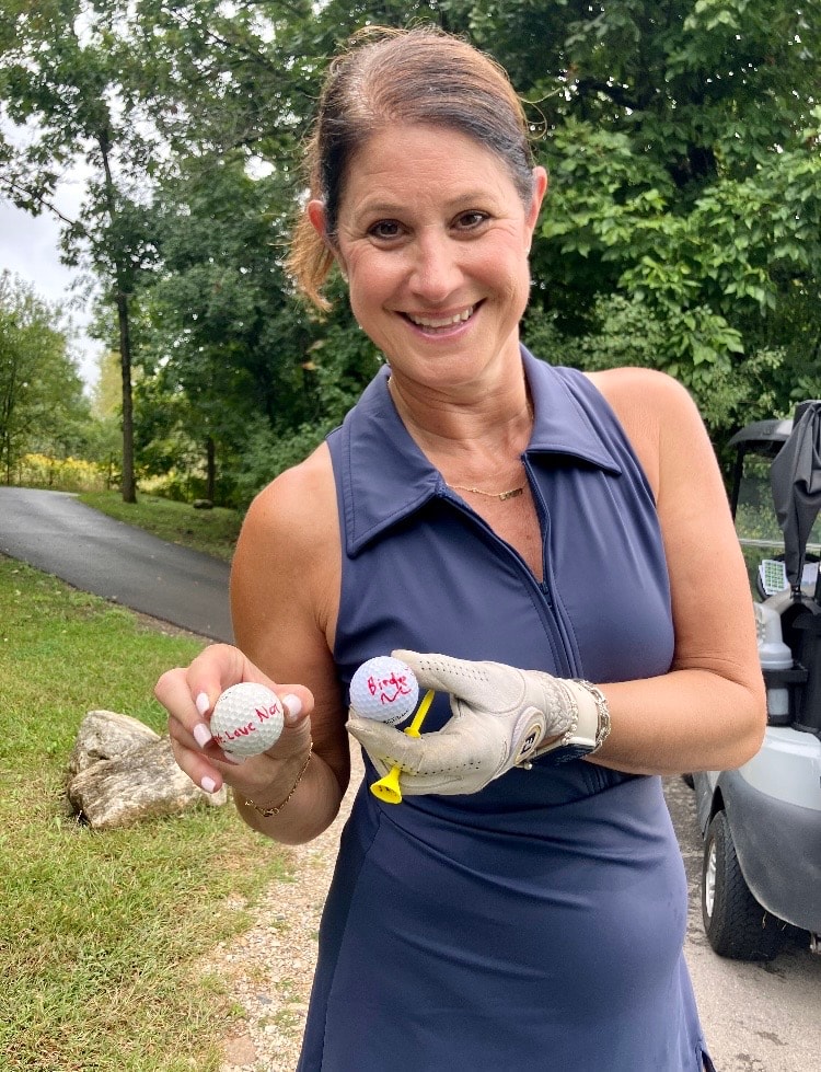 Woman holding signed baseballs outdoors