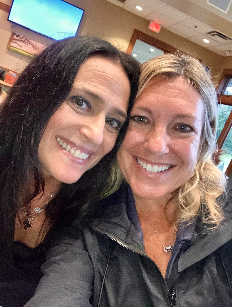 Two women smiling together indoors