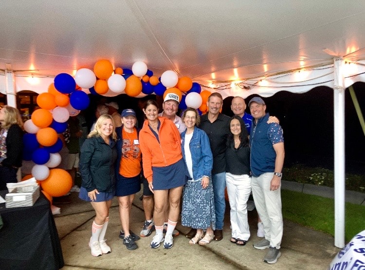 Group posing under festive balloon tent
